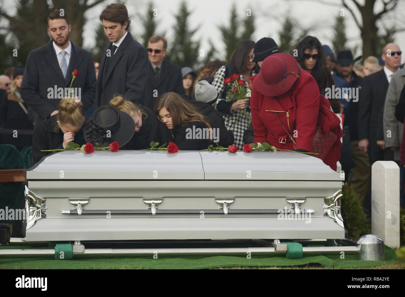 Us Air Force Maj. Troy Gilbert's Familie Rosen auf seine Schatulle während seiner Beisetzung auf dem Arlington National Cemetery Dez. 19, 2016. Gilbert war Nov. 27, 2006 getötet, während fliegen, eine Mission zur direkten Unterstützung der Koalition Boden Kampfhandlungen, wenn seine F-16C Fighting Falcon ca. 20 Meilen nordwestlich von Bagdad abgestürzt. Dies war der dritte beisetzung Für den Flieger in Arlington seit 2006 und vereint bleibt in diesem Jahr wieder mit teilweise noch ursprünglich in den Jahren 2006 und 2012 erholt. Stockfoto