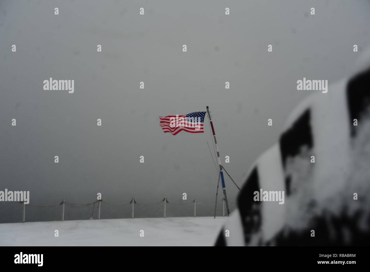 Die Fahne fliegt an Bord der Flugzeugträger USS George Washington (CVN 73) im Winter Storm Helena. Das Schiff ist in Norfolk, Virginia für die Betankung komplexe Überholung (RCOH) Wartung homeported. Stockfoto