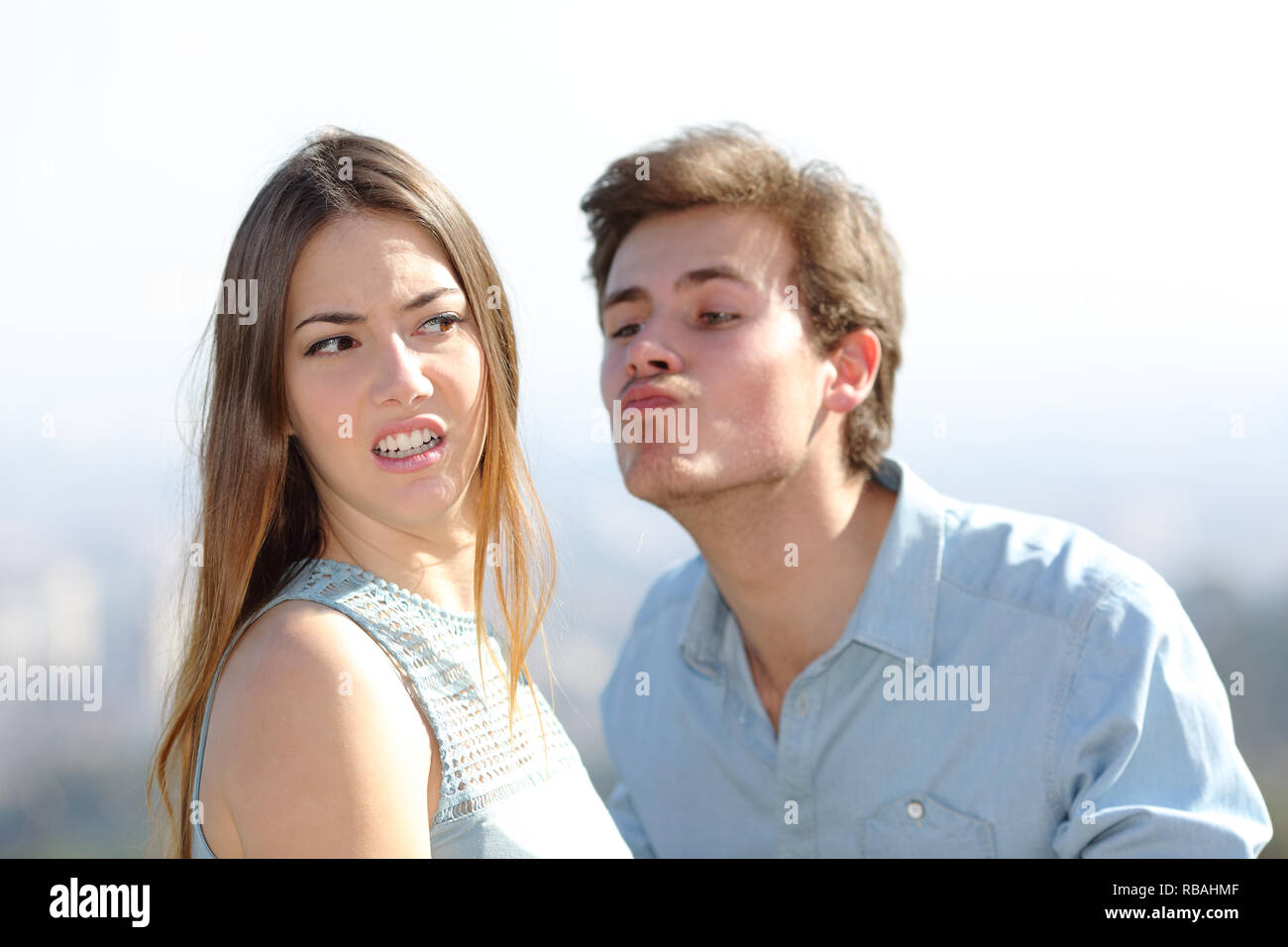 Wütende Frau lehnt einen Freund Kuss an einem sonnigen Tag Stockfoto
