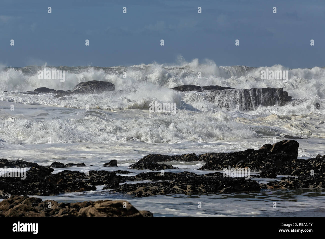 Große, weiße Wellen in einem felsigen Strand aus dem Norden von Portugal brechen Stockfoto
