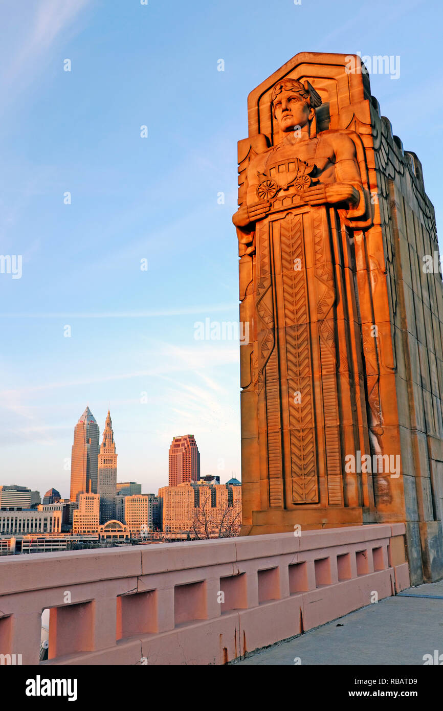 Einer der acht Stein Art déco-Masten auf der Hope-Memorial Bridge mit der Downtown Skyline im Hintergrund in Cleveland, Ohio, USA. Stockfoto