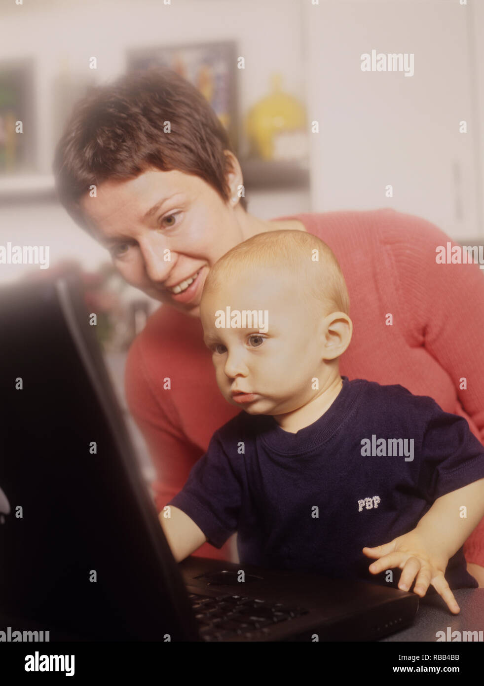 Mutter und Kleinkind Sohn auf einem Laptop Bildschirm die Zeit zusammen genießen. Stockfoto