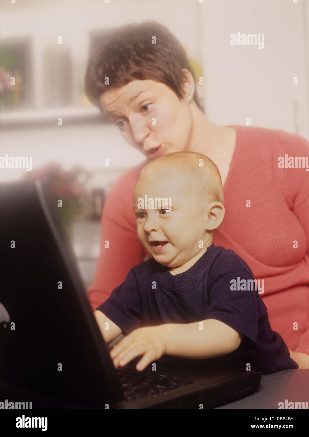 Mutter und Kleinkind Sohn auf einem Laptop Bildschirm die Zeit zusammen genießen. Stockfoto