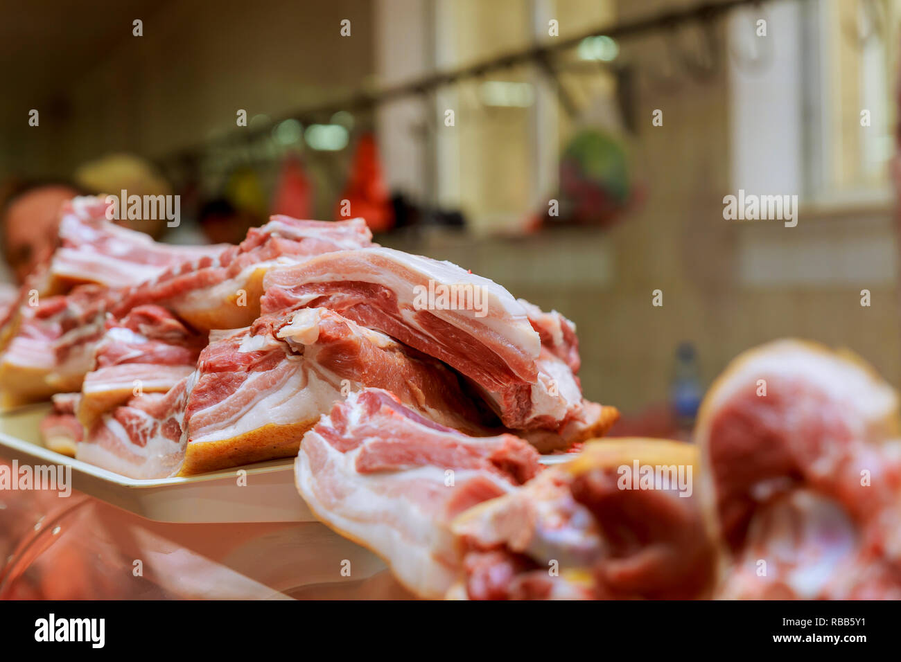 Metzger schneidet ein Stück Fleisch auf dem Markt die Hände eines Metzgers schneiden Scheiben von rohem Fleisch Stockfoto