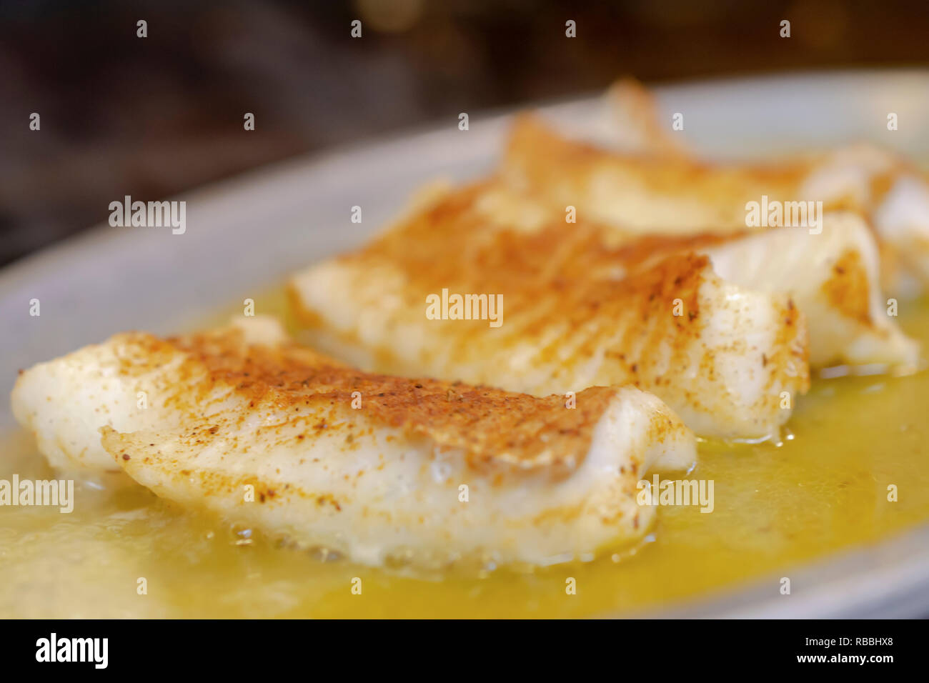 Drei gebackene gegrillte Fisch Filets in Butter auf dem Teller dampfender auf Restaurant Grill. Makro geschossen zu schließen. Zimmer für Kopieren. Stockfoto