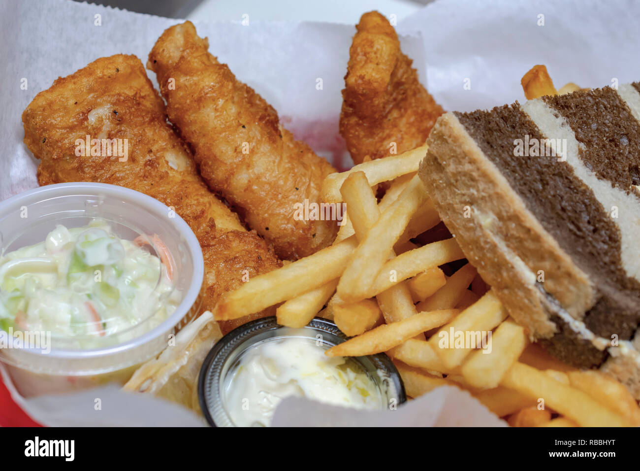 Das Essen in der Bar: typische Freitag Nacht fisch braten in Wisconsin. Gebratener Kabeljau, Pommes frites, Krautsalat, Remoulade und marmoriert Roggenbrot in einem Korb. Stockfoto