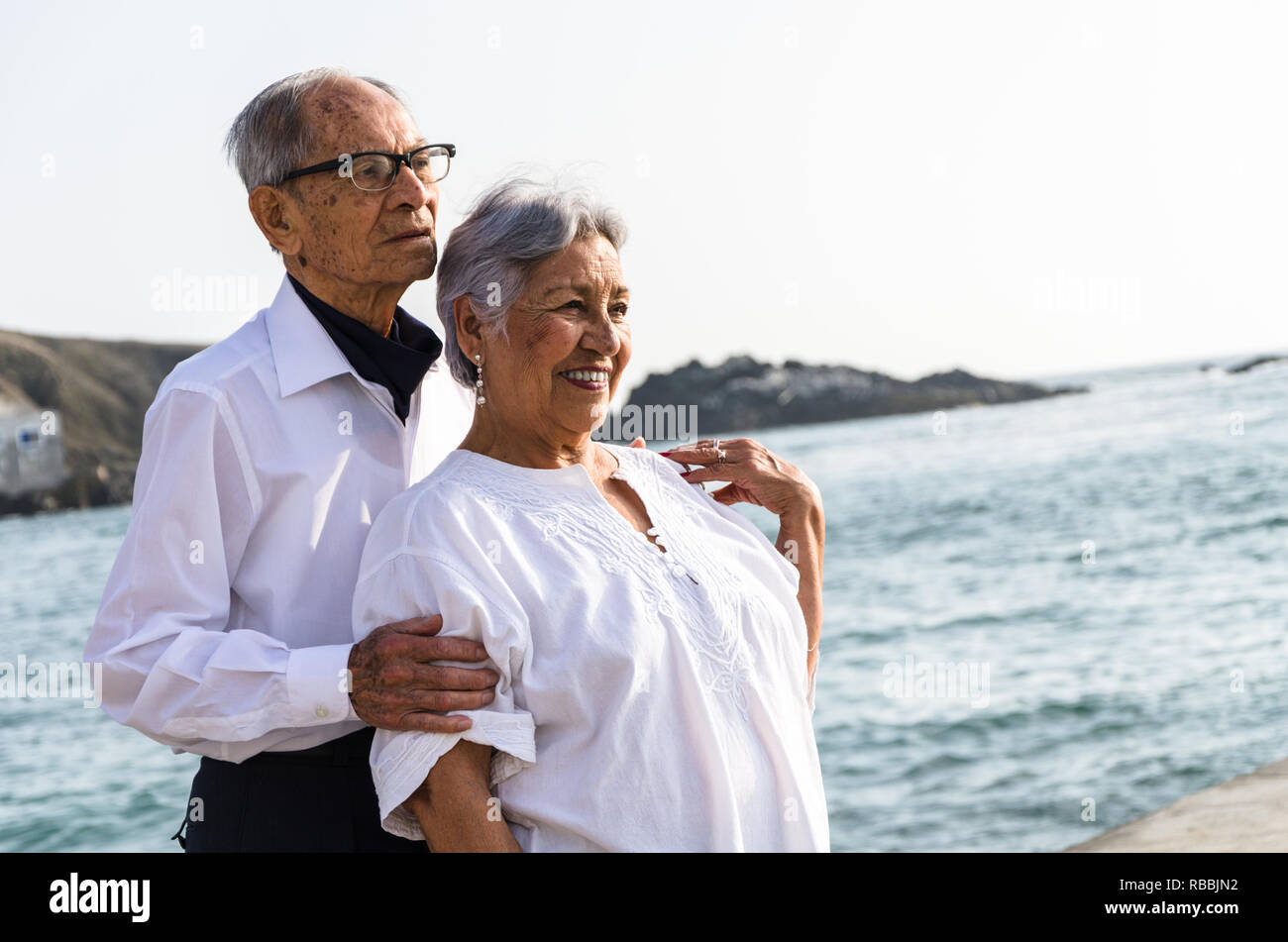 Senior Paar einander umarmen am Strand an einem sonnigen Tag Stockfoto