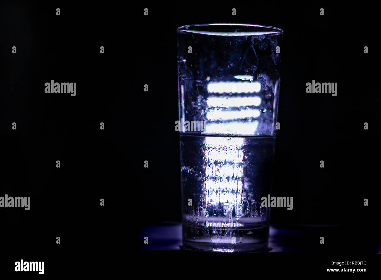 Konzept: Eis schmelzen - flüssiges Wasser, durch helle LED-Hintergrundbeleuchtung Stockfoto