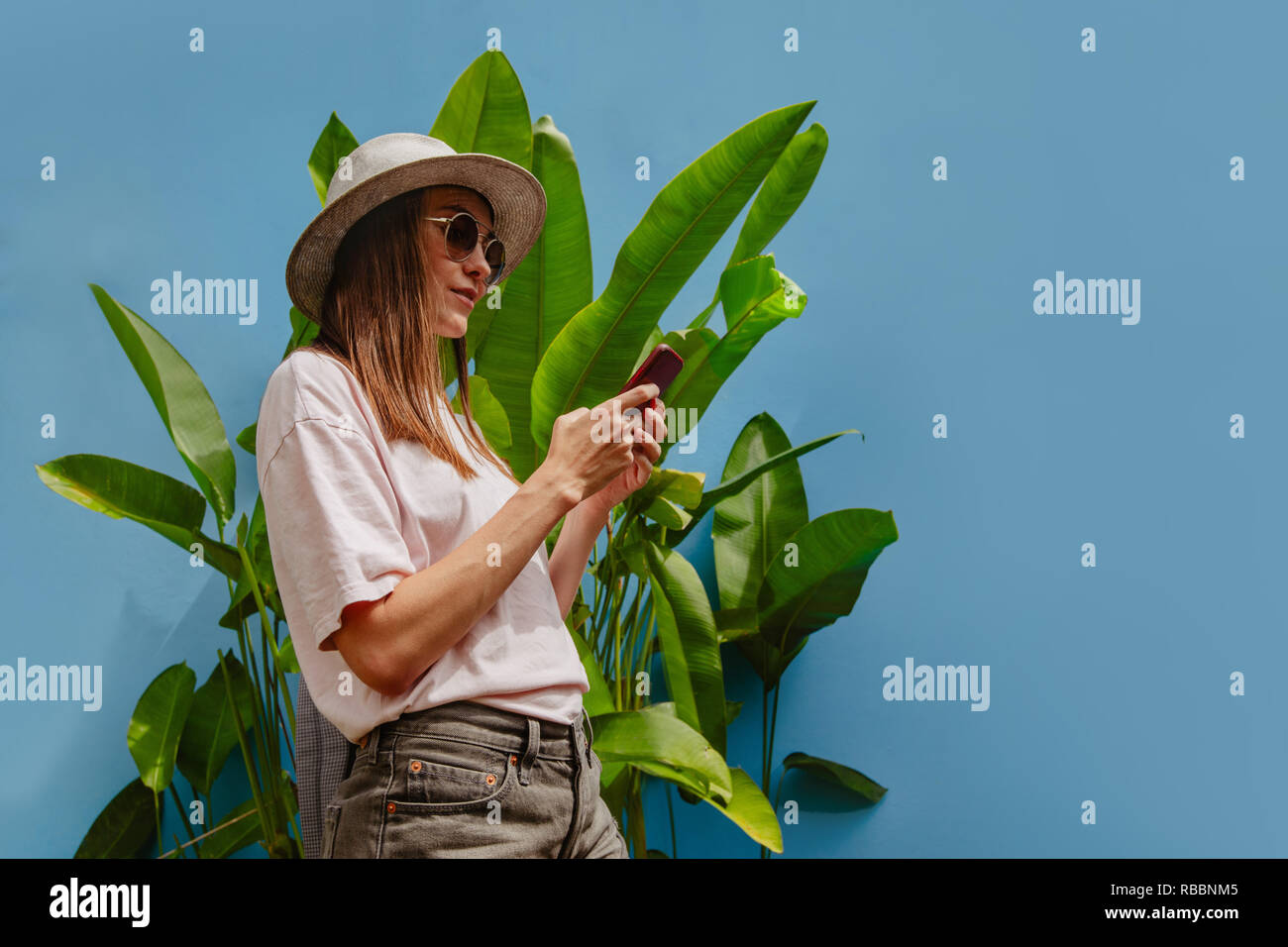 Neugierige junge Frau im Urlaub verwendet Smartphone Stockfoto