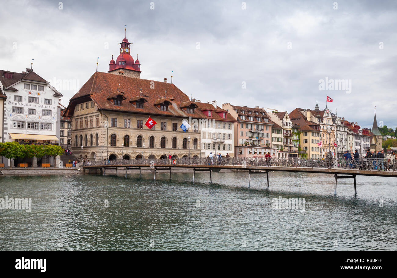 Luzern, Schweiz - 7. Mai 2017: Stadtbild der Stadt Luzern, dem Rathaus und der Brücke über die Reuss. Gewöhnliche Menschen gehen auf die Straße Stockfoto