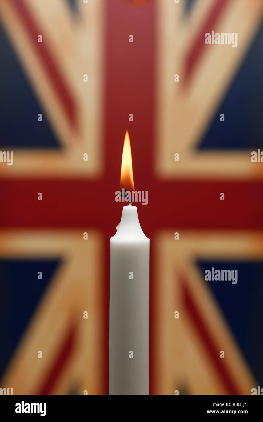 Eine einzelne weiße Kerze gegen eine Union Jack Flagge Stockfoto