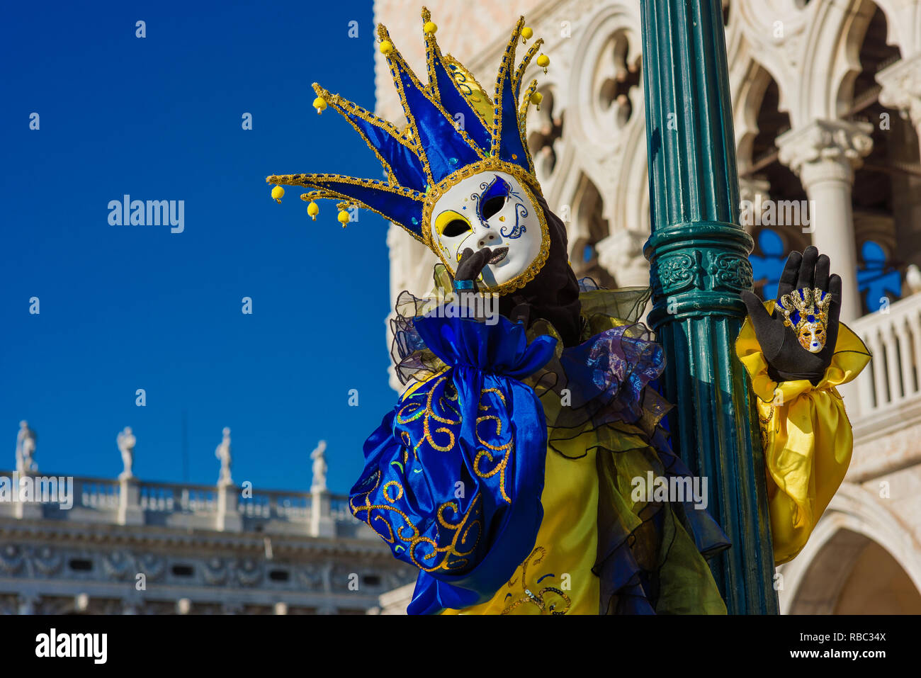 Karneval in Venedig. Eine wunderschöne venezianische Maske mit Jester's Cap vor dem Dogenpalast Stockfoto