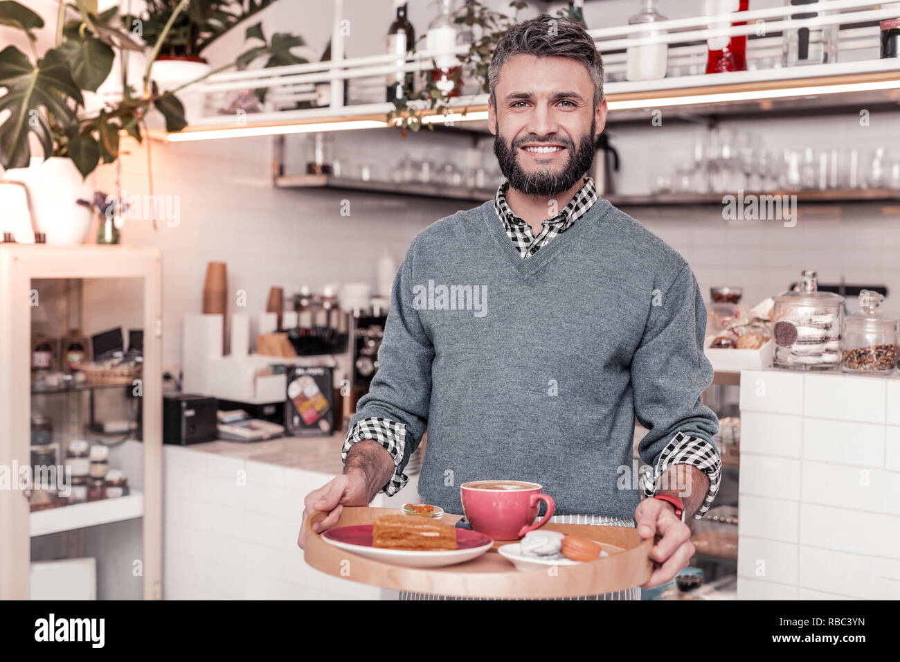 Positive bärtiger junger Mann, Sie lächeln Stockfoto