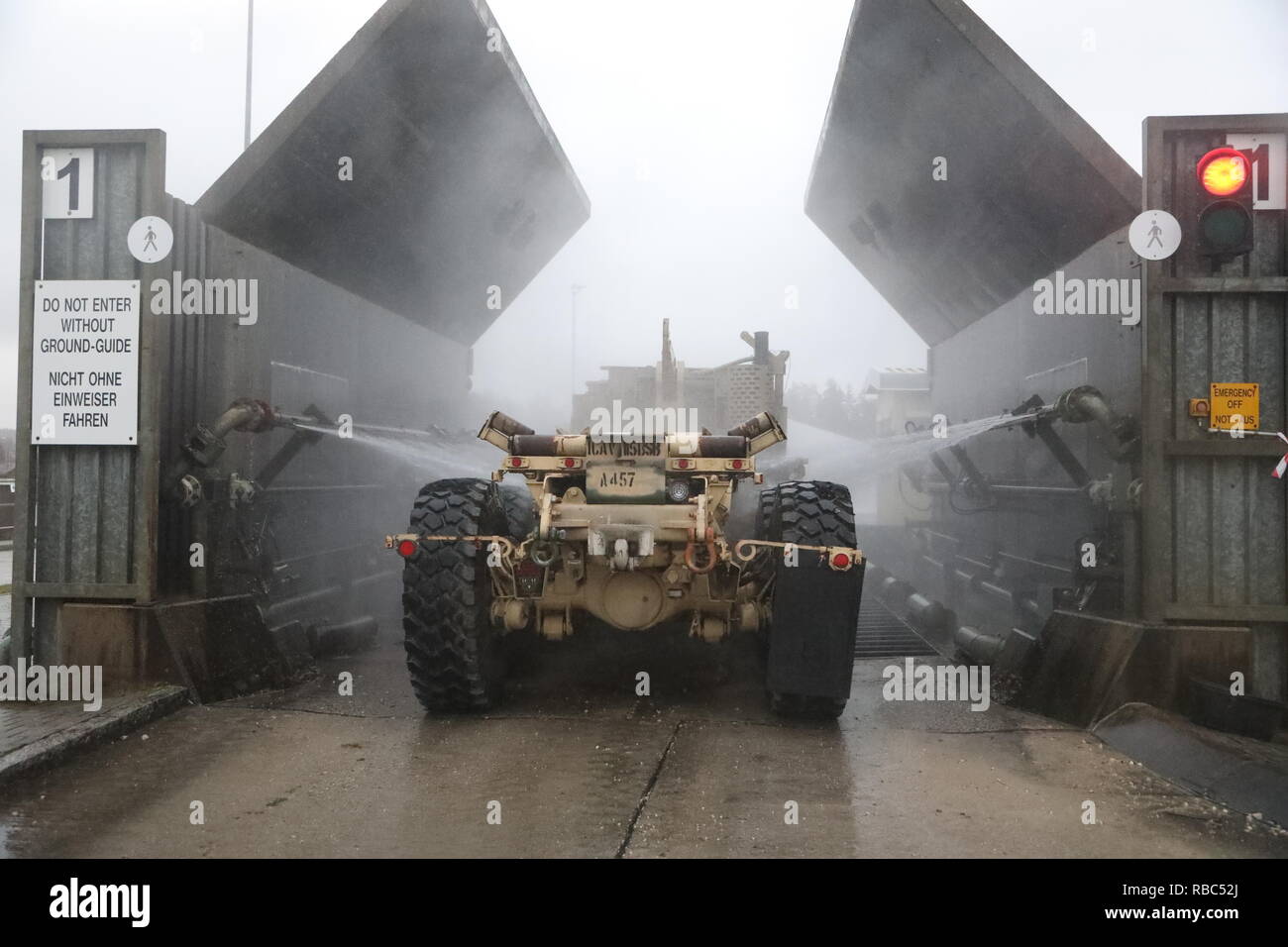 Ein Soldat der US-Armee die 115 Brigade Support Bataillons, 1st Armored Brigade Combat Team, 1.Kavallerie Division, mans seine Fahrzeuge zugewiesen, wie es in der Wäsche Rack im Camp Aachen in Grafenwoehr gereinigt wird, Deutschland Jan. 7, 2019. Die ironhorse Brigade ist Waschen Fahrzeuge als Teil der Glattstellung Anforderungen für ihre Unterstützung der Atlantischen lösen in Europa. (U.S. Army National Guard Foto: Staff Sgt. Ron Lee, 382 Öffentliche Angelegenheiten Loslösung, 1 ABCT, 1 CD) Stockfoto