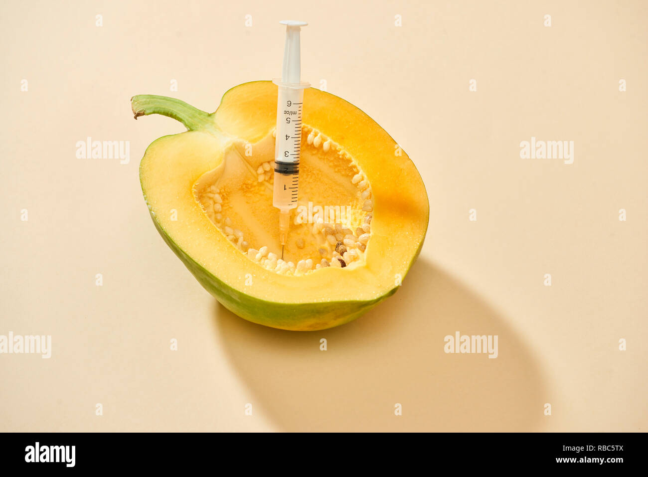 Helle reife Papaya mit Spritze Extrahieren von Flüssigkeit und zeigt Konzept der Cellulite Behandlung Stockfoto