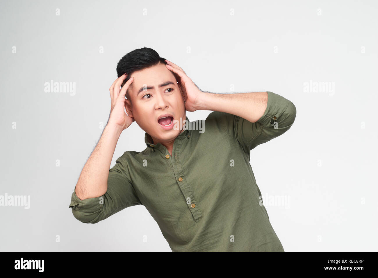 Oh nein! Portrait von überrascht, schockiert Mann mit Stoppeln und weit geöffneten Mund und Augen in kariertem Hemd berühren Kopf mit beiden Händen isoliert auf Grau Stockfoto