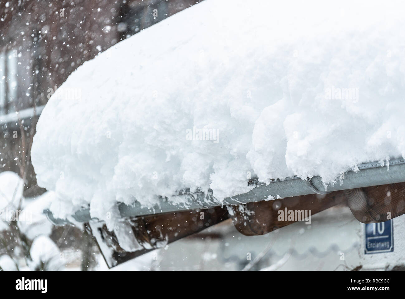 Schneeverwehungen auf dem Dach nach zwei Tagen Schneefälle. Dicke Schichten hängen auf dem Hausdach. Deutschland Bayern Stockfoto