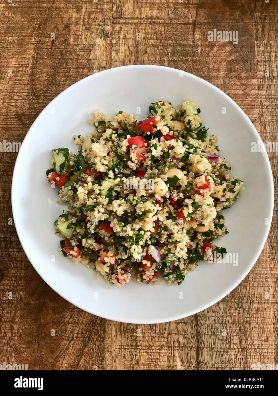Eine gesunde und farbenfrohe vegan Quinoa Salat auf einem Holztisch Stockfoto