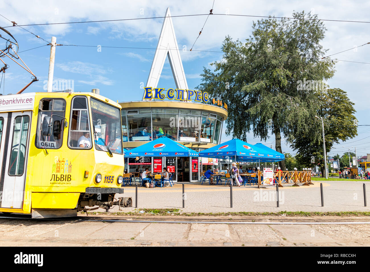 Lemberg, Ukraine - Juli 30, 2018: Außerhalb von Lwow Bahnhof Gebäude mit Trolley Bus Straßenbahn in historischen ukrainischen Stadt im Sommer, Gelb und Blau colo Stockfoto