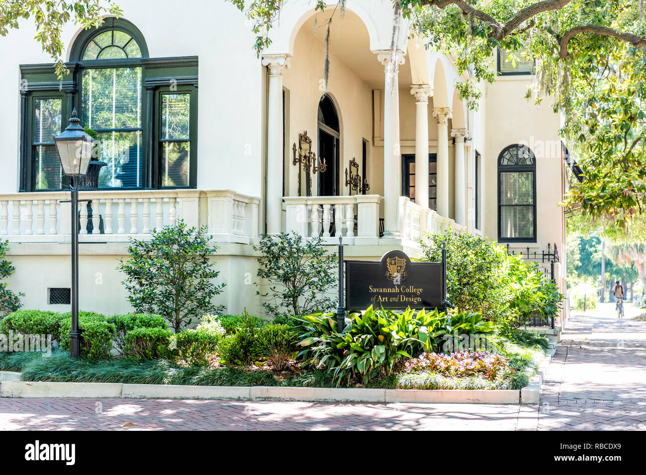 Savannah, USA - 11. Mai 2018: die Straße in der Nähe von Forsyth Park, Georgia während der sonnigen Tag im Sommer mit weißen Architektur Gebäude und melden Sie sich für die Hochschule von Ar Stockfoto