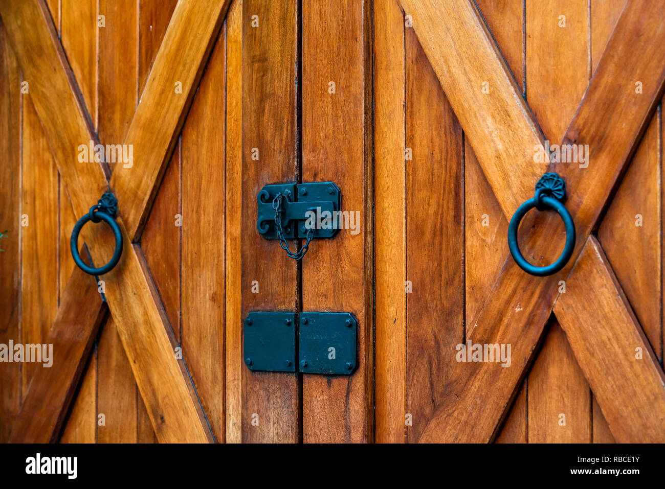 Bauernhof rustikales Haus Eingang mit braun-orange Farbe von Holz- oder Holz Tür und schwarzer Griff abstrakte Closeup auf Charleston in South Carolina mit Kreuz Stockfoto