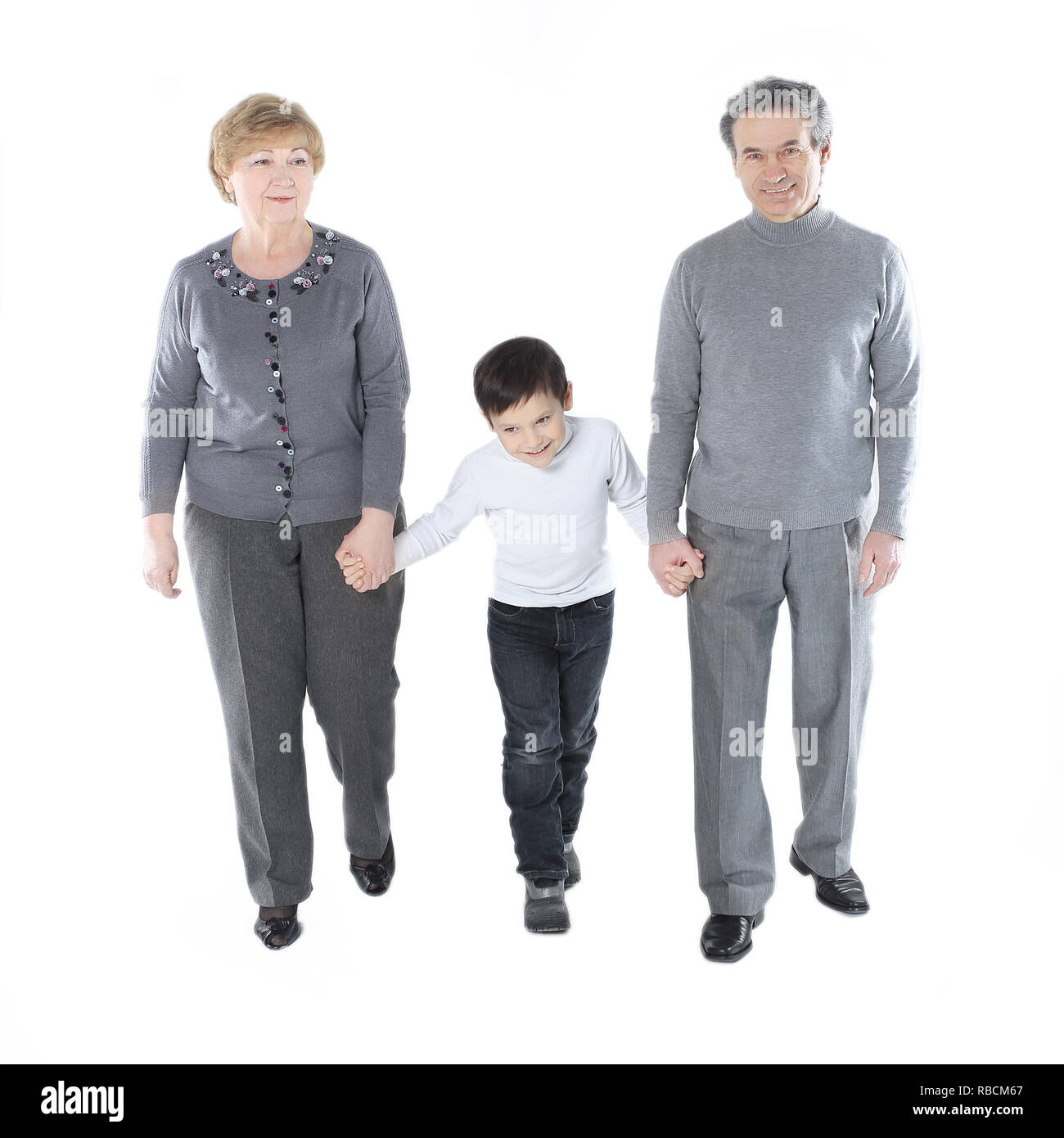 Oma und Opa gehen mit ihrem Enkel. auf weißem Hintergrund Stockfoto