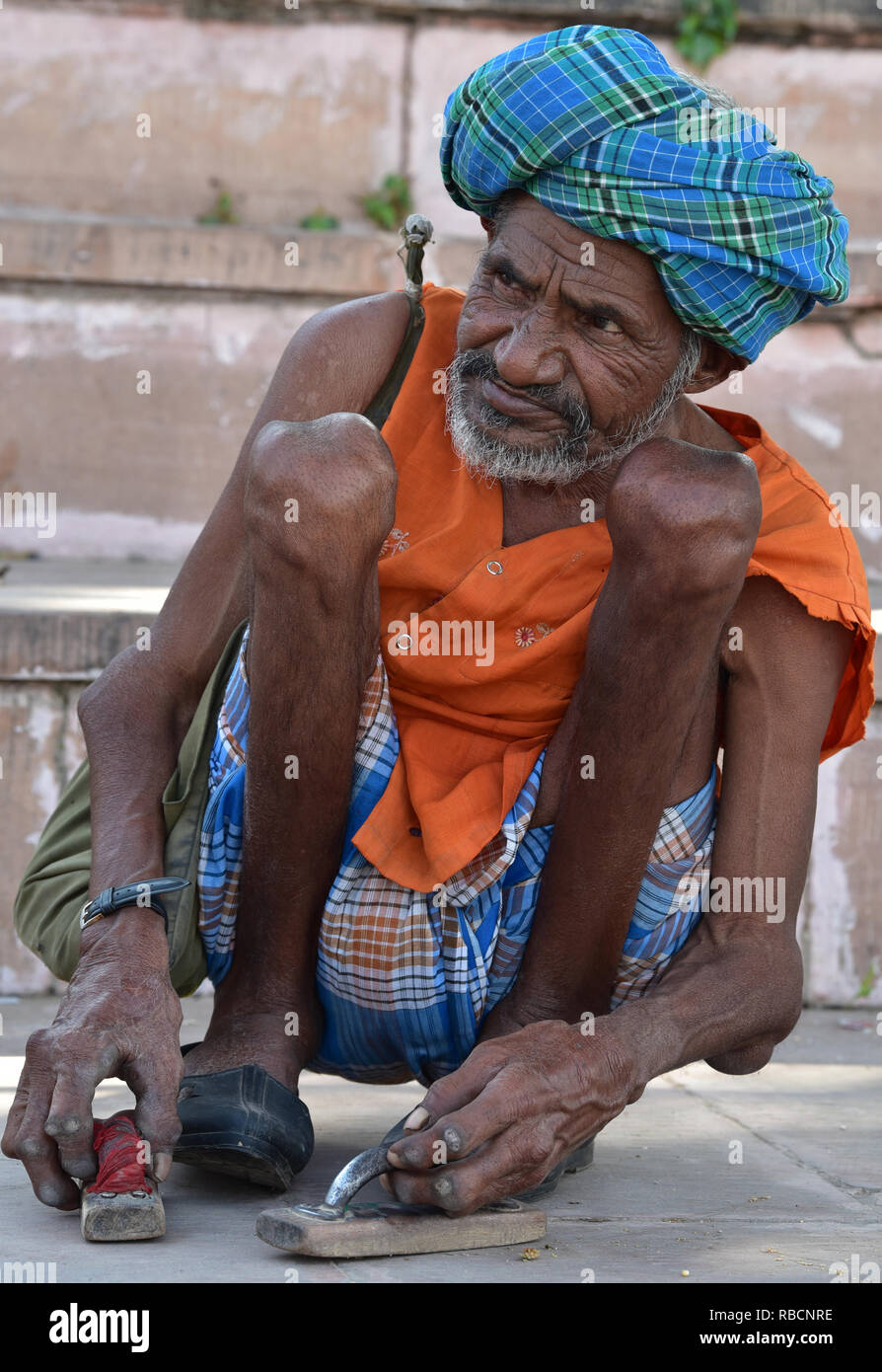 Indische Mann zusammengekauert am Ufer des heiligen Pushkar-see, Rajasthan, Indien, Asien. Stockfoto