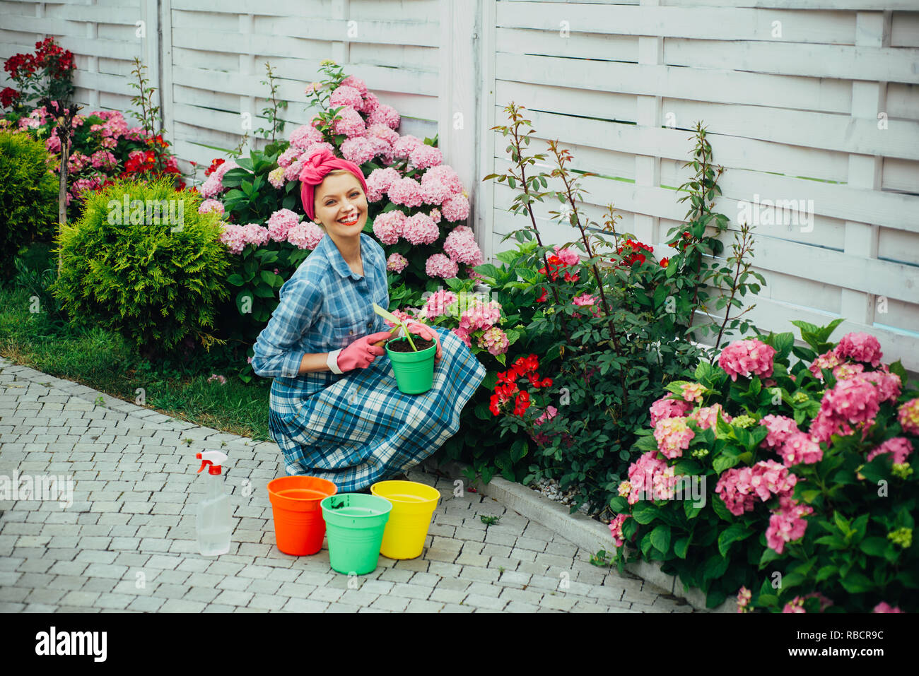 Glückliche Frau Gärtner mit Blumen. Gewächshaus Blumen. Blumen Pflege