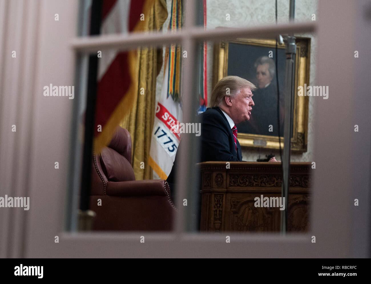 Washington, Vereinigte Staaten von Amerika. 08 Jan, 2019. Präsident Donald Trump ist durch das Fenster des Oval Office gesehen, wie er einen primetime Adresse auf der Government Shutdown liefert und seinen Antrag auf Bereitstellung von Mitteln für über 5 Mrd. $ für eine südliche Grenze Mauer, im Weißen Haus, Washington, DC Foto von Kevin Dietsch/UPI | Verwendung der weltweiten Kredit: dpa/Alamy leben Nachrichten Stockfoto