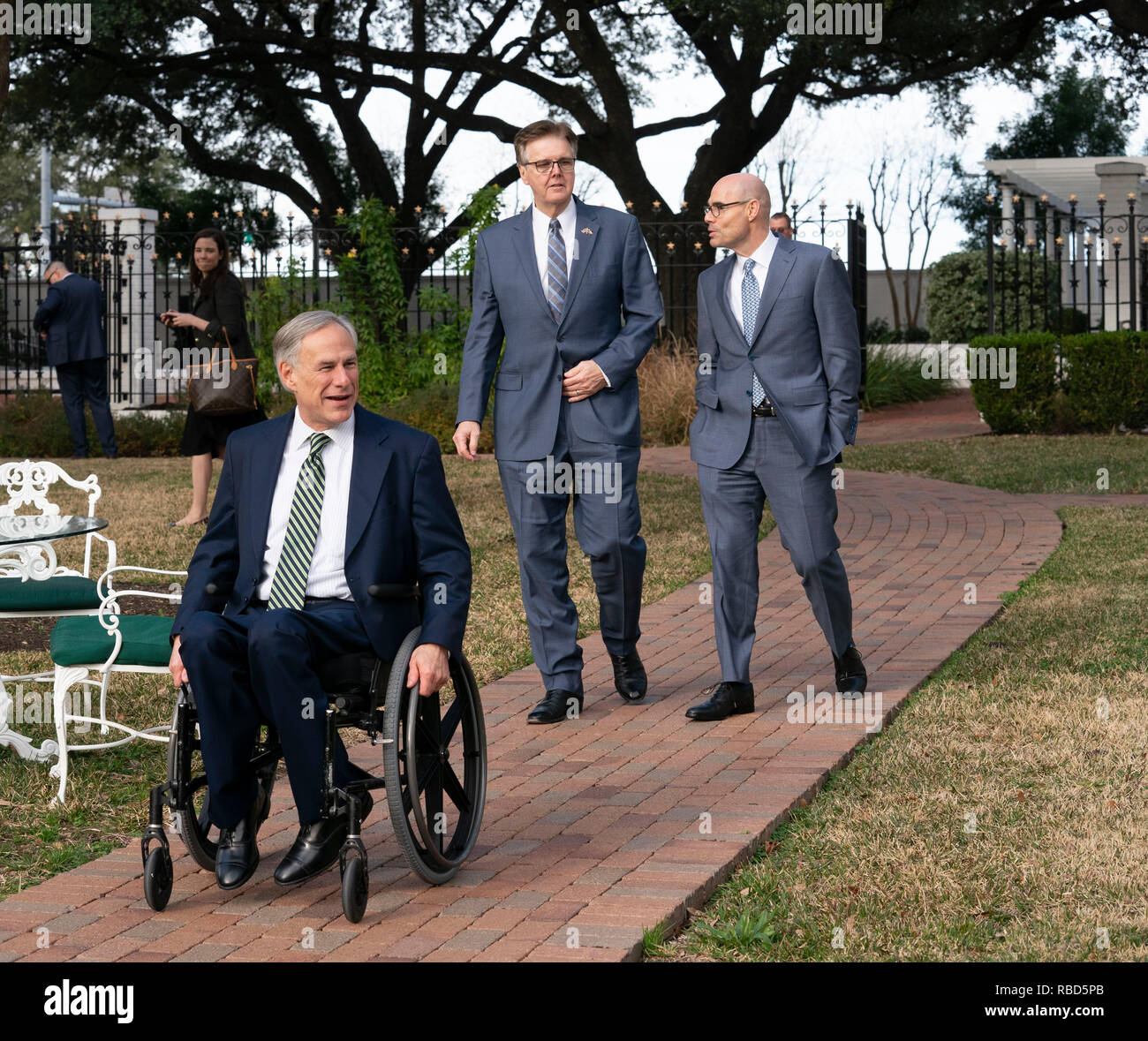 Texas politische Führer reg. Greg Abbott (im Stuhl), Leutnant. Dan Patrick, und Sprecher des Repräsentantenhauses Dennis Bonnen Spaziergang auf dem Gelände der Texas Governor's Mansion in Austin vor der Presse zu Beginn der 86. Legislaturperiode. Stockfoto