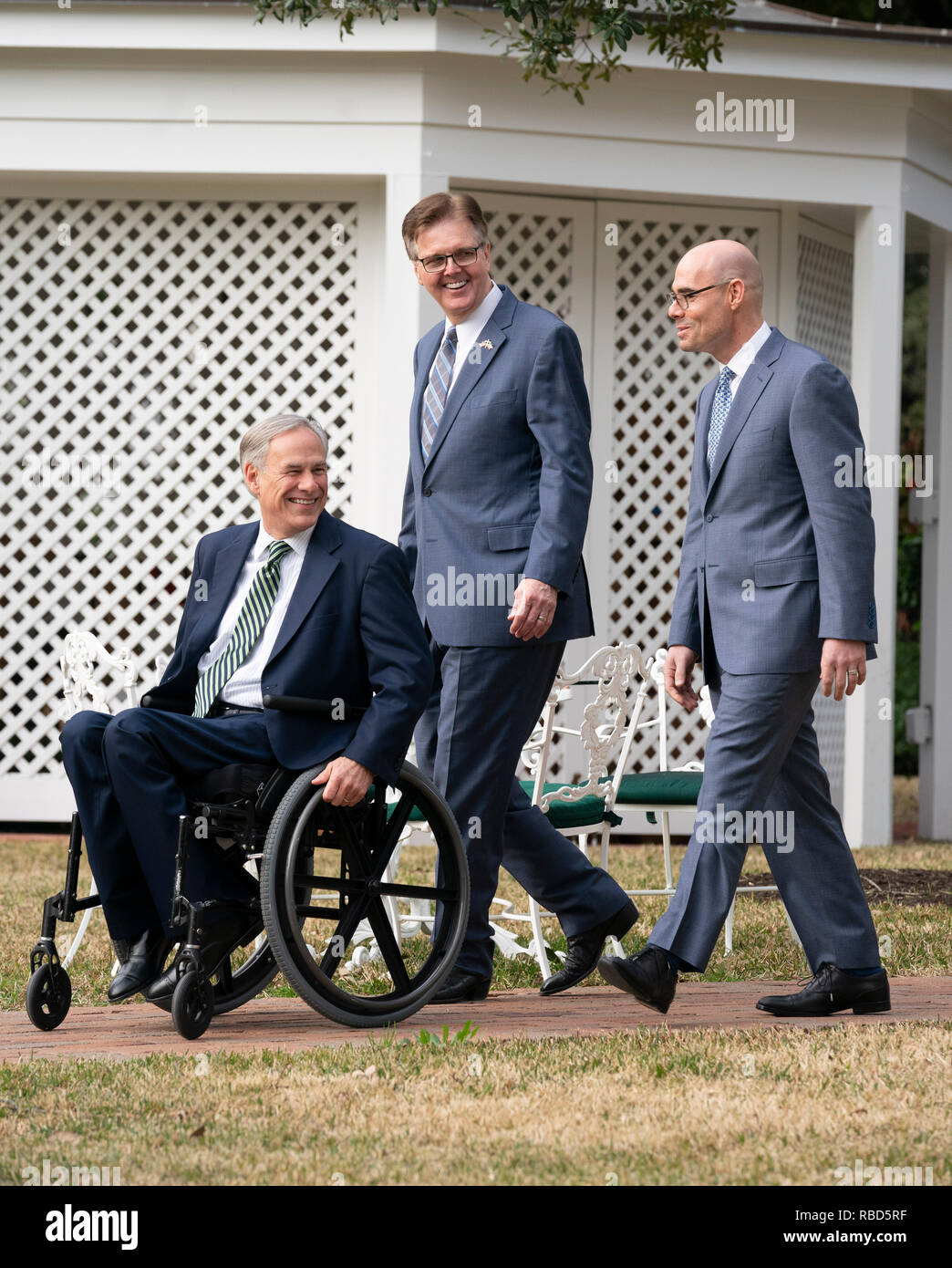 Texas politische Führer reg. Greg Abbott (im Stuhl), Leutnant. Dan Patrick, und Sprecher des Repräsentantenhauses Dennis Bonnen Spaziergang auf dem Gelände der Texas Governor's Mansion in Austin vor der Presse zu Beginn der 86. Legislaturperiode. Stockfoto