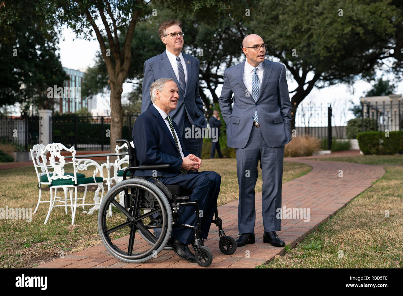 Texas politische Führer reg. Greg Abbott (im Stuhl), Leutnant. Dan Patrick, und Sprecher des Repräsentantenhauses Dennis Bonnen Spaziergang auf dem Gelände der Texas Governor's Mansion in Austin vor der Presse zu Beginn der 86. Legislaturperiode. Stockfoto