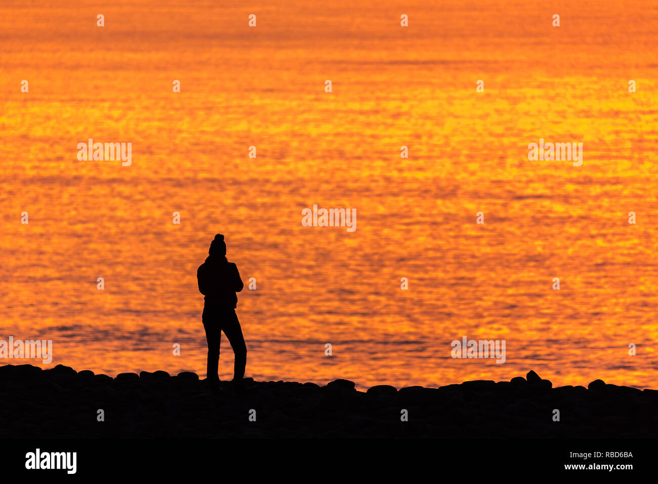 Aberystwyth, Ceredigion, Wales, UK. 09 Jan, 2019. UK Wetter: Menschen genossen Ein farbenfroher Sonnenuntergang über der Westküste von Aberystwyth am Ende eines kalten frostigen Tag. Credit: Ian Jones/Alamy leben Nachrichten Stockfoto