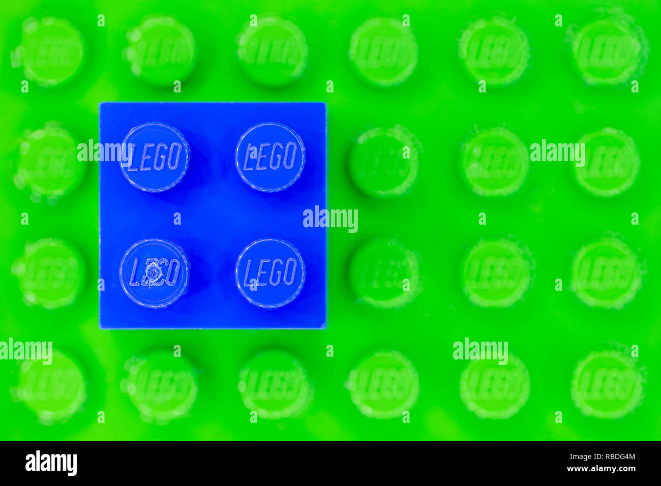 Blau 2x2 LEGO Stein auf einem grün Lego base Stockfoto