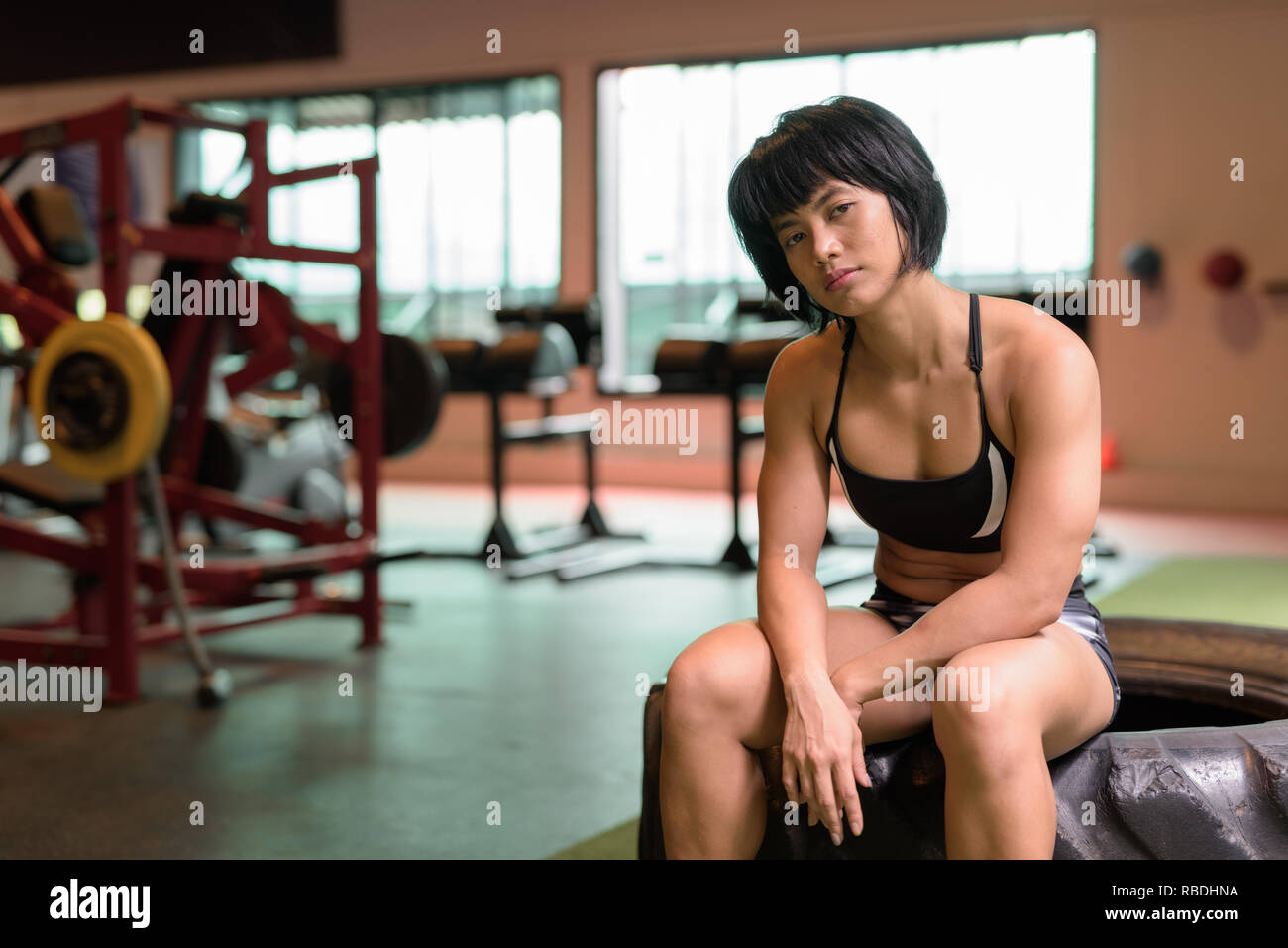 Junge schöne asiatische fitness Frau an der Turnhalle sitzen Stockfoto