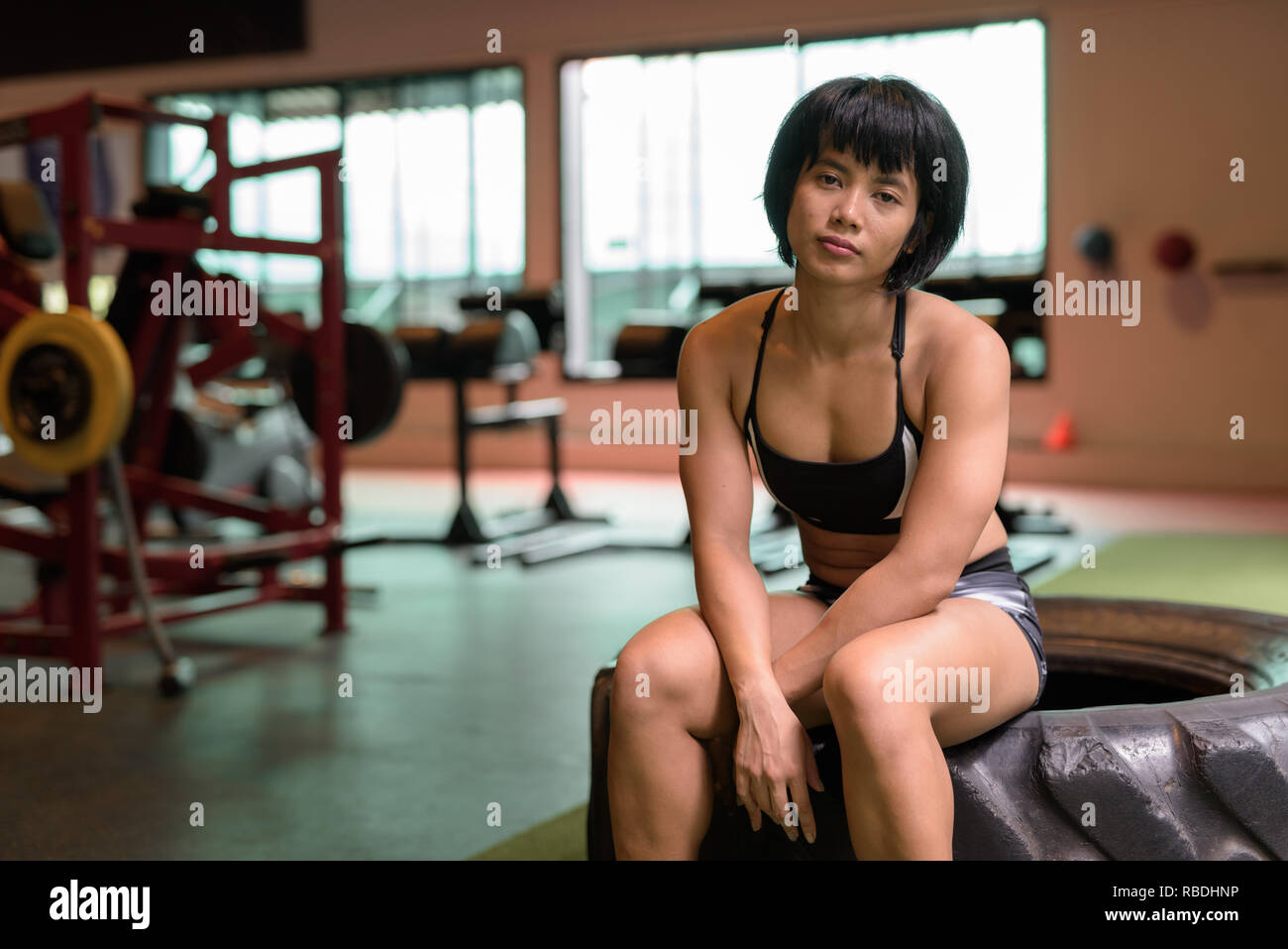 Junge schöne asiatische fitness Frau an der Turnhalle sitzen Stockfoto