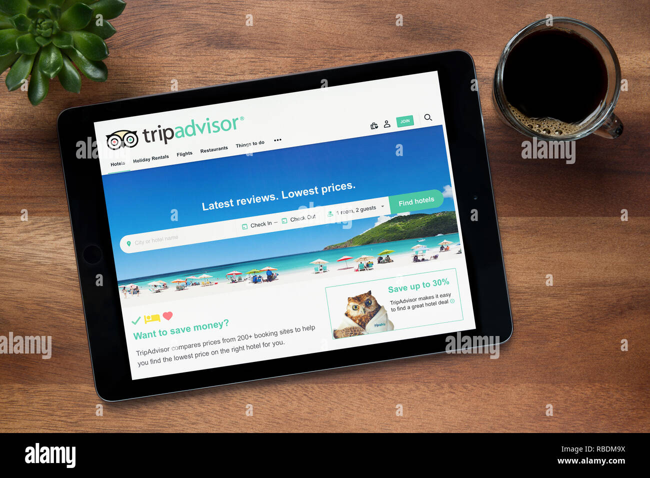 Die Website von Trip Advisor ist auf einem iPad Tablet gesehen, auf einer hölzernen Tisch zusammen mit einem Espresso und einem Haus Anlage (nur redaktionelle Nutzung). Stockfoto