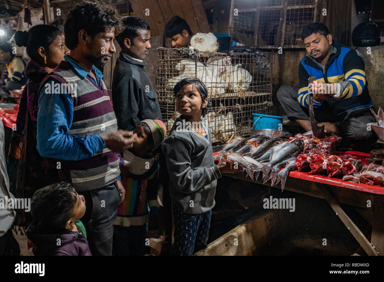 Die Fische Stall in JJ Kolonie, Madanpur Khadar: Am Abend ist der Marktstand ist am geschäftigsten - ein junger Verkäufer nutzt wichtige Fähigkeiten der Verhandlung Stockfoto
