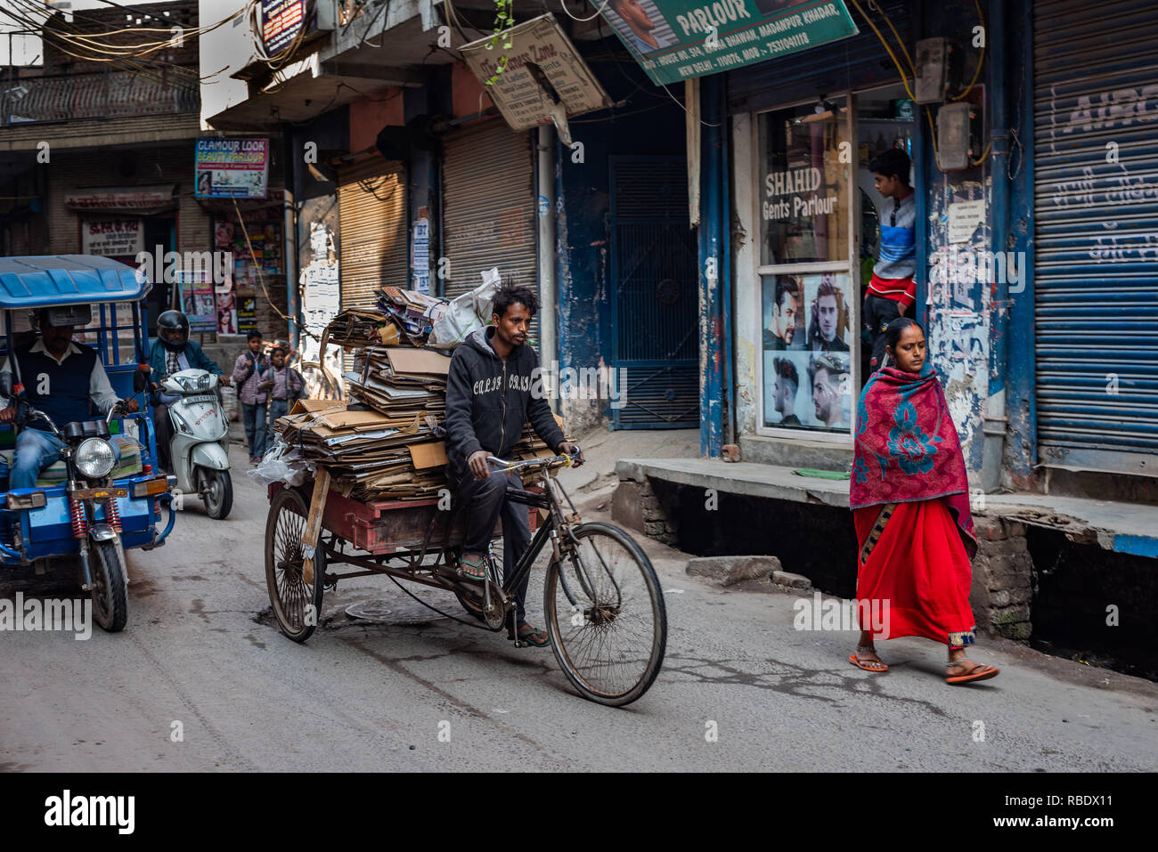 Verkehrsträger in den belebten Madanpur Khadar Village, New Delhi: Cycle rickshaw, Rikscha und ein Fußgänger Stockfoto