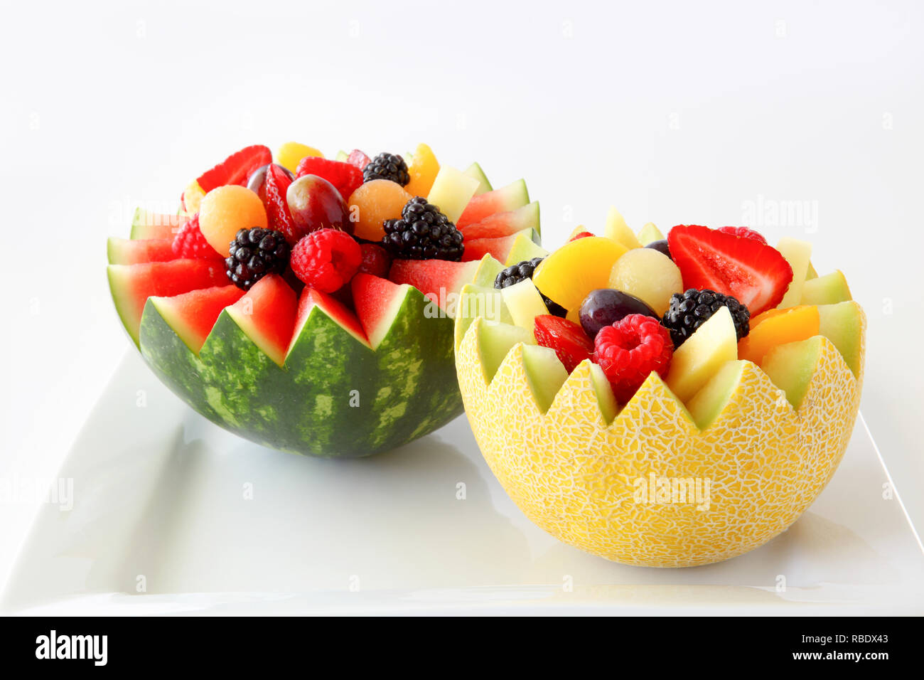 Fancy cut Melone und Wassermelone mit sortierten Obst innen inicluding Erdbeeren, Himbeeren, Weintrauben, Canteloupe, Ananas, Pfirsiche in Scheiben geschnitten Stockfoto