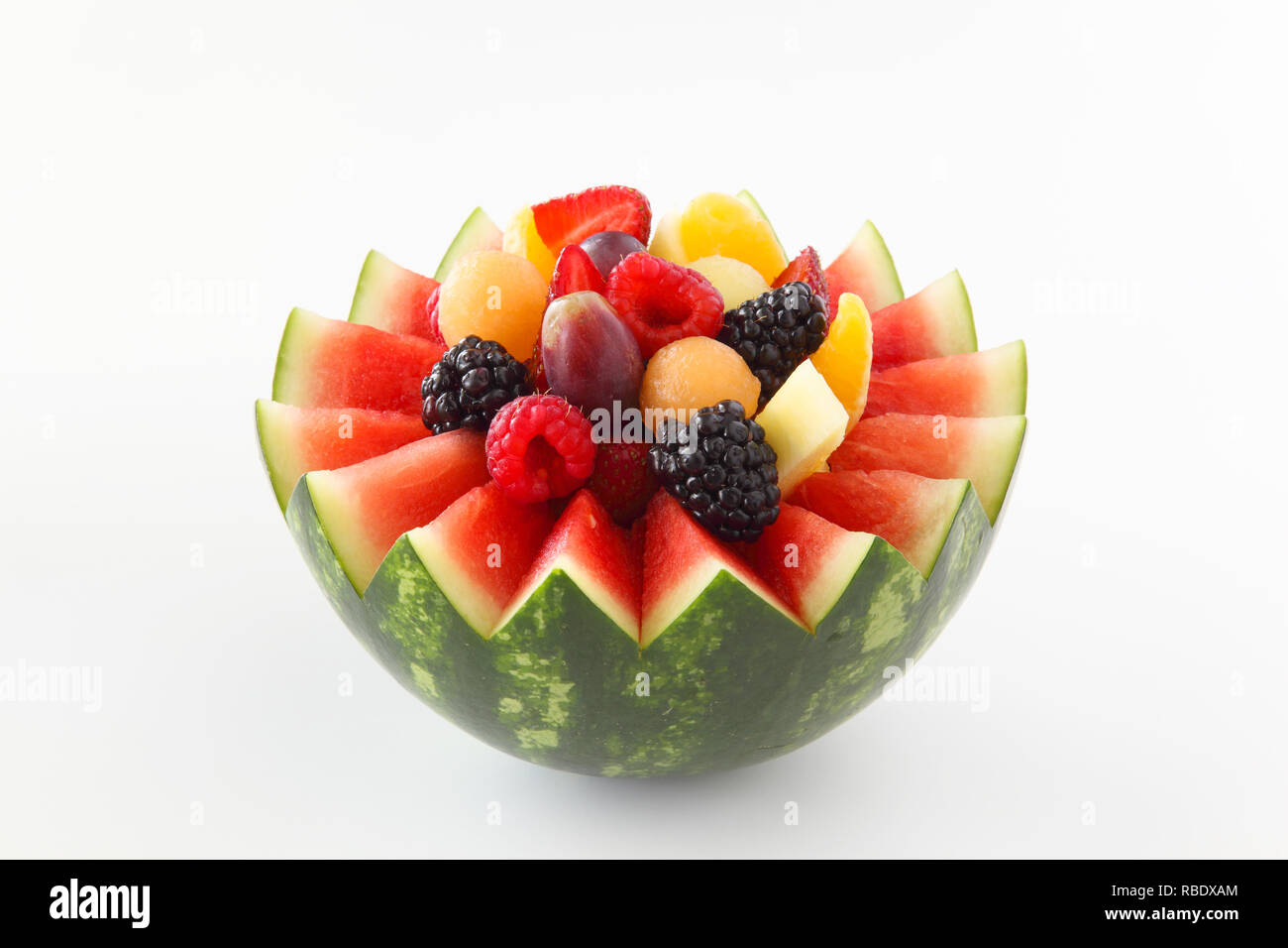 Fancy cut Wassermelone auf weißem Hintergrund mit sortierten Obst wie Beeren, Trauben, Ananas, Orangen Stockfoto