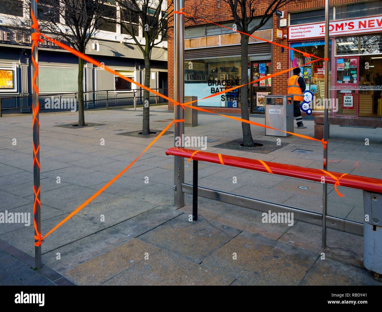 Ein Stadtzentrum Bushaltestelle mit Glasscherben mit orangefarbenem Klebeband abgeklebt, über die Gefahr zu warnen. Stockfoto