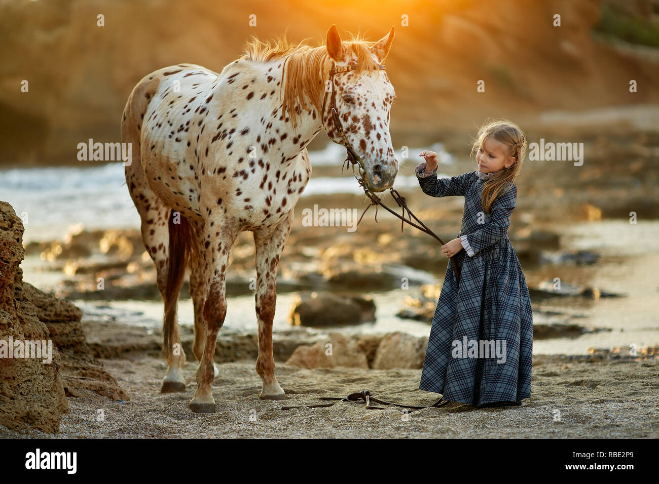 Mädchen im Kleid wandern mit Pferd Stockfoto