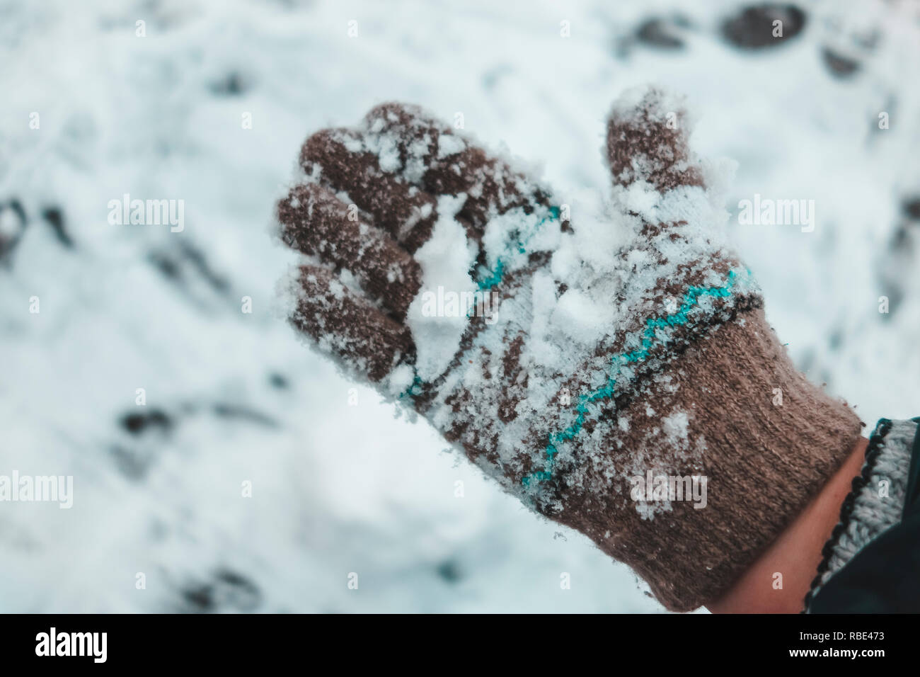Die Hände des Kindes auf gestrickte wollene Handschuhe im Schnee Stockfoto