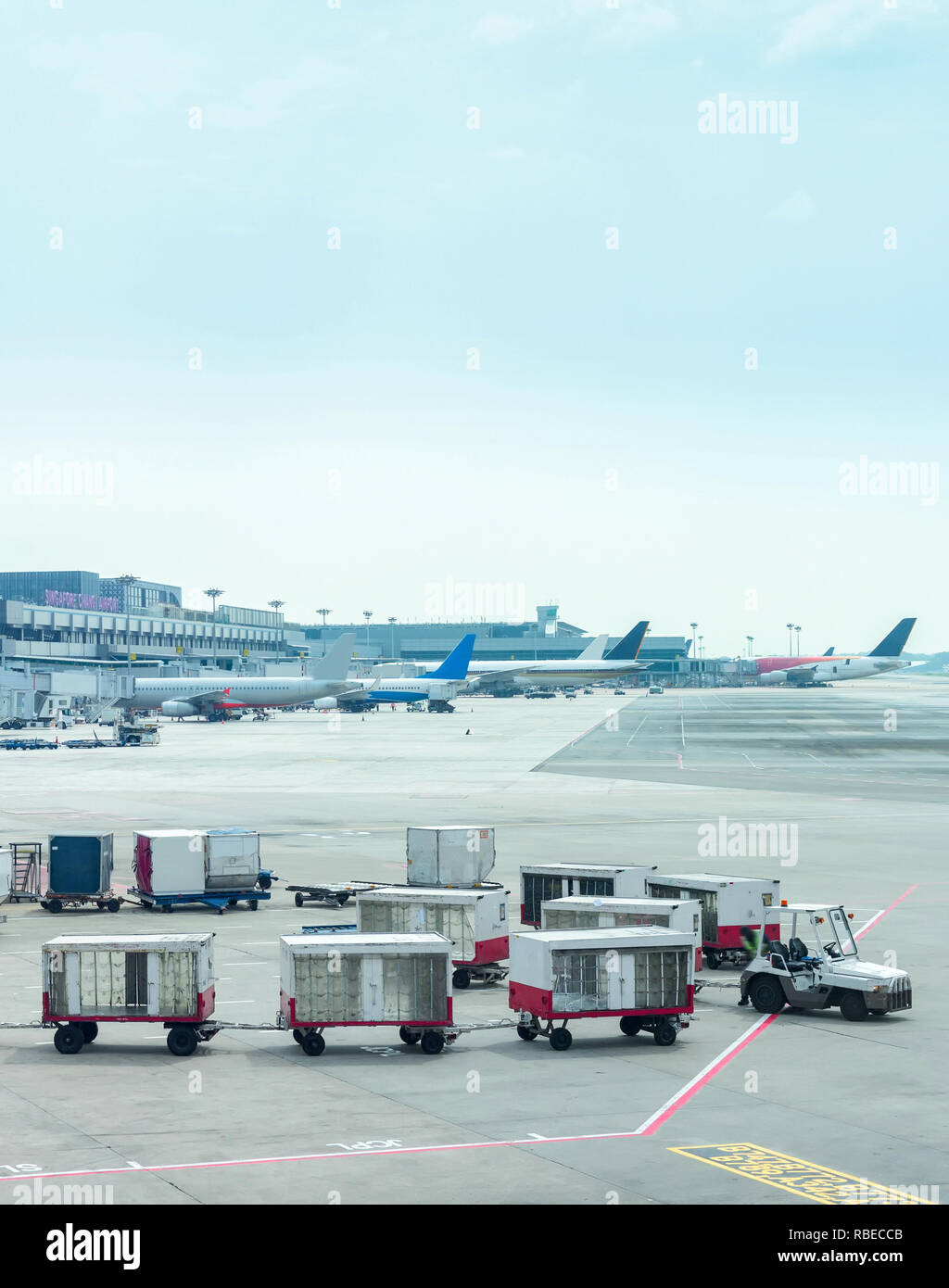 Gepäck Kutschen durch die Gangway am Changi Airport Terminal mit Flugzeugen, Singapur Stockfoto