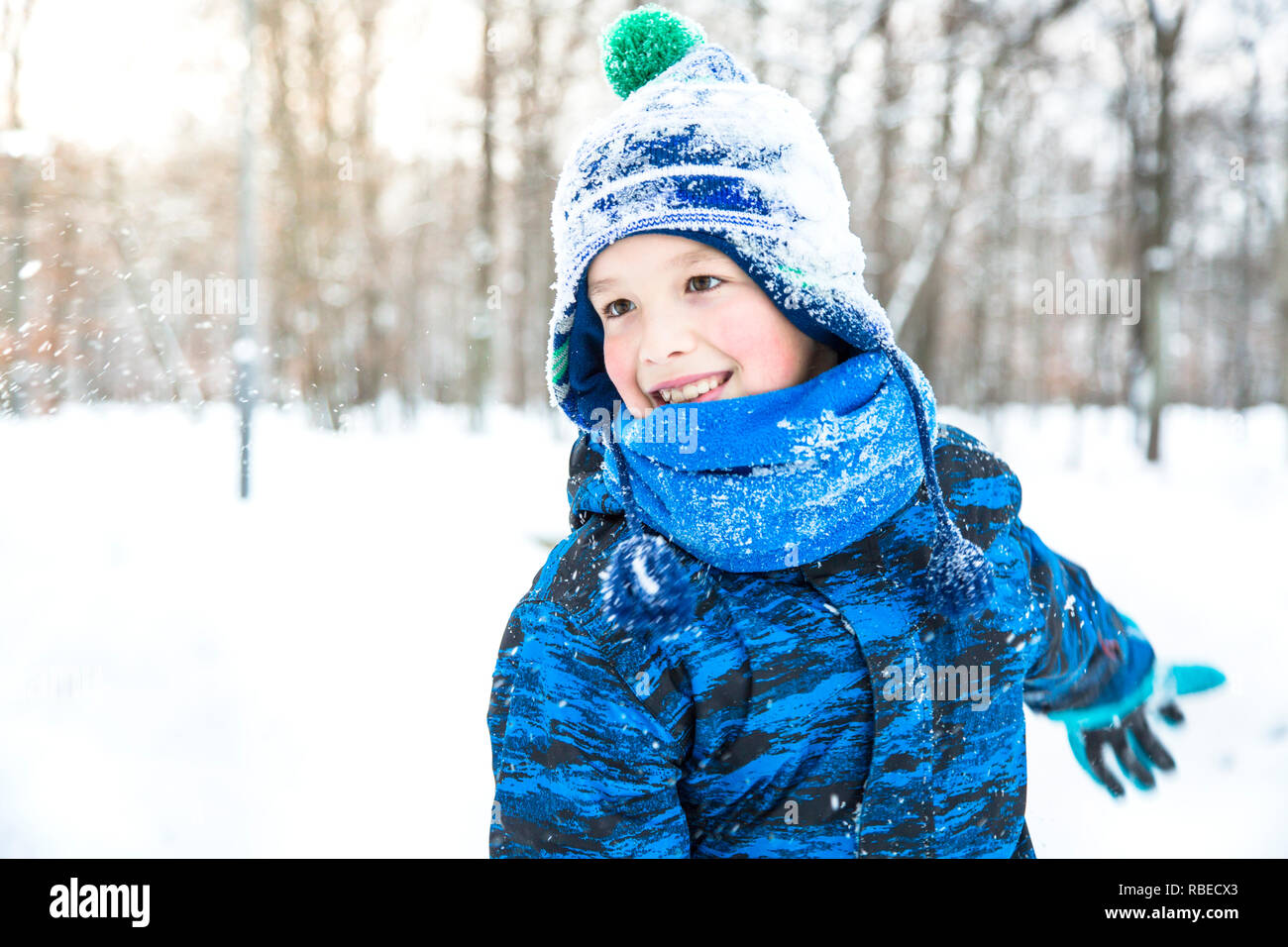 Glückliches Kind Junge spielt Schneebälle outdoor. Stockfoto