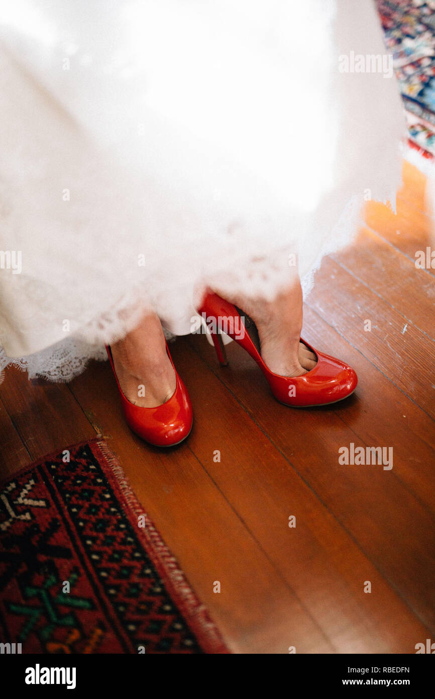 Braut im Brautkleid auf rote Schuhe Stockfotografie - Alamy