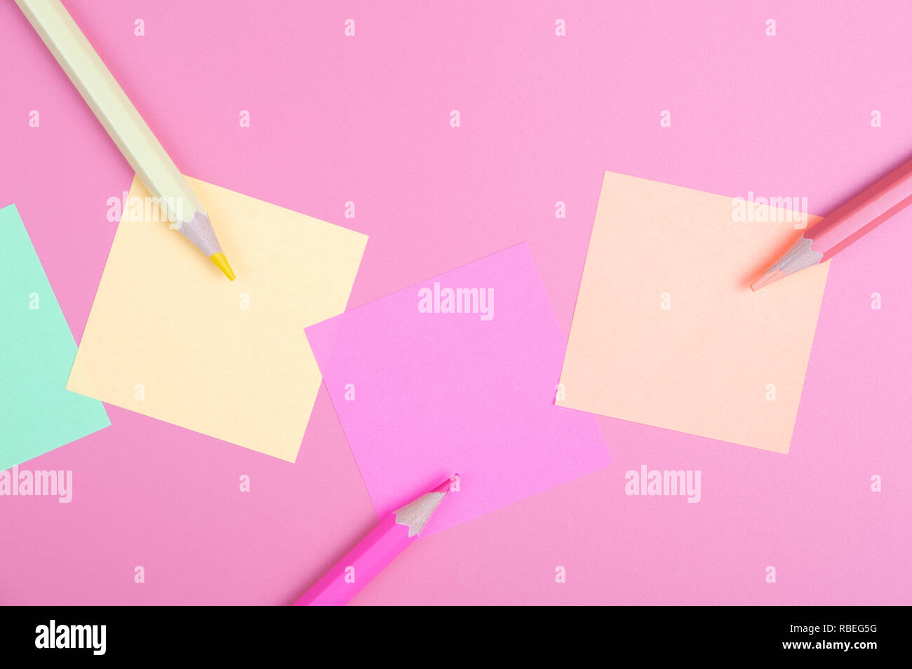 Buntstifte und farbiges Papier auf rotem Hintergrund Stockfoto