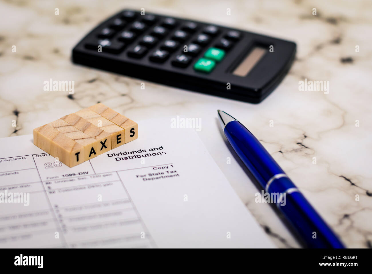 Steuern still life Business Finance Konzept, Form 1099, Dividenden und Verteilung, mit Taschenrechner, Kugelschreiber flach DOF Stockfoto