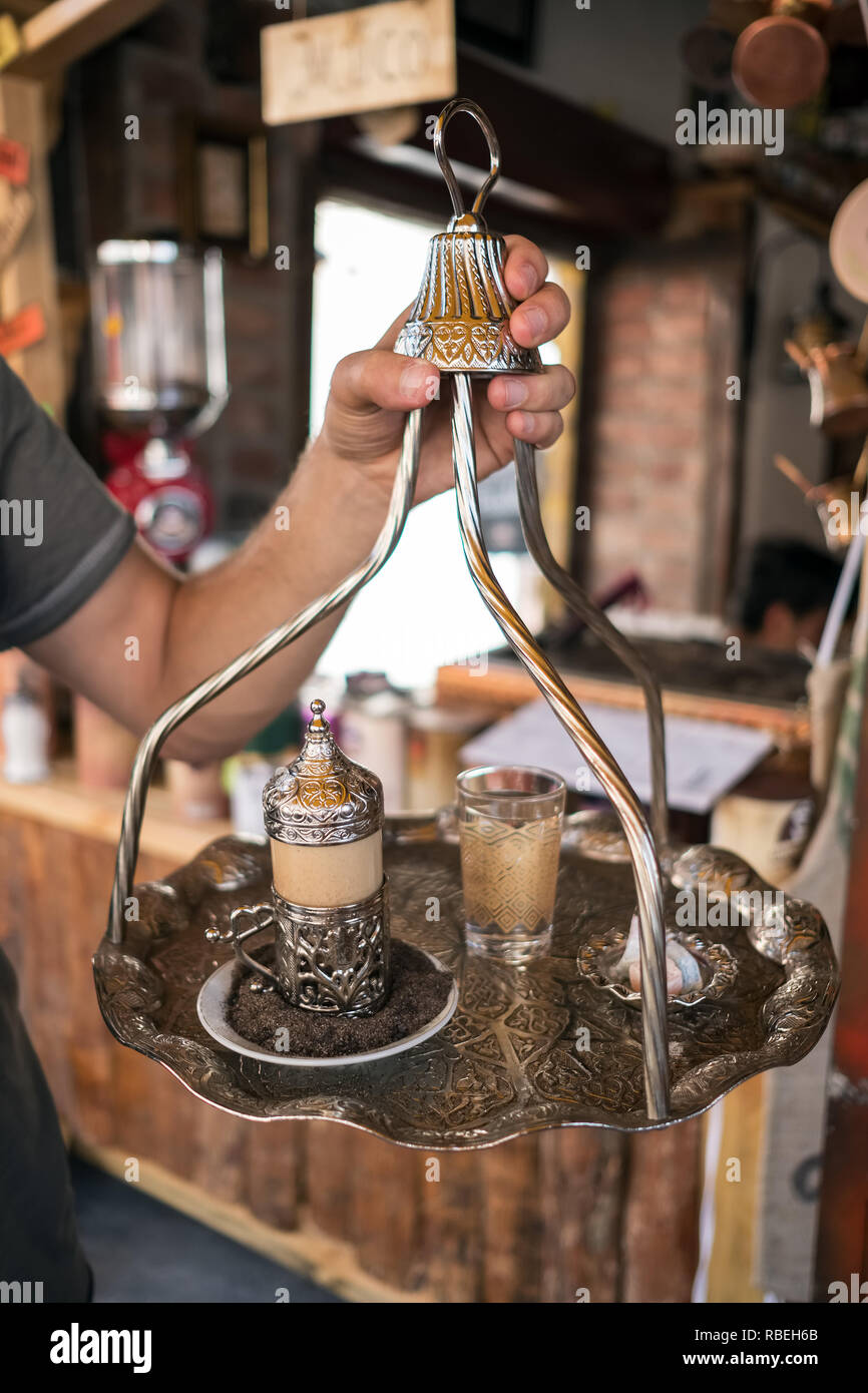 Traditionelle türkische Kaffee serviert in einem wunderschönen Metall Schale am heißen Sand mit einem Glas Wasser und Turkish Delight im Outdoor Cafe in Ankara, Türkei Stockfoto